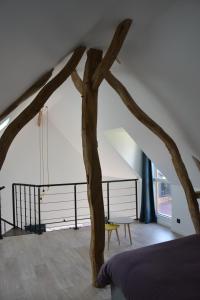 La Dépendance d'En Face : غرفة نوم مع فرع شجرة في وسط الغرفة