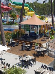 a restaurant with tables and chairs and a roller coaster at Mobilhome Eleganzia 713 Bonne Anse Plage in Les Mathes