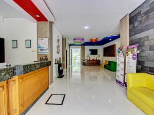 een woonkamer met een gele bank en een lobby bij Super OYO Collection O 92254 Hotel By Orchid in Duwet