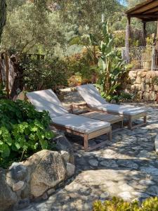 two chaise lounges in a garden with rocks at Villa Adriana - Torre delle Stelle - mini appartamenti - Cagliari Villasimus Sardegna in Torre delle Stelle