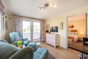 a living room with blue chairs and a bedroom at Appartement Am Park der Sinne & Am See in Binz