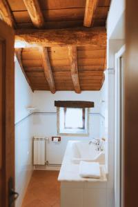 baño blanco con lavabo y ventana en Casa Do Romualdo, en Vilela
