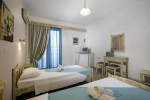 a hotel room with two beds and a desk at Kalathos Sun Hotel in Kalathos