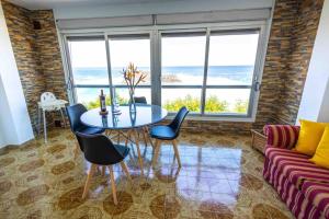 un soggiorno con tavolo, sedie e divano di Frontline Penthouse - Prixmar - by VV Canary Ocean Homes a El Pris