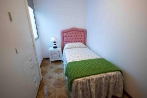 una piccola camera da letto con un letto con una coperta verde di Frontline Penthouse - Prixmar - by VV Canary Ocean Homes a El Pris