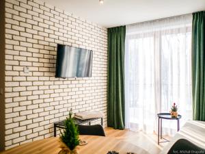 ein Wohnzimmer mit einem TV an einer Backsteinwand in der Unterkunft Przy Szlaku in Zawoja