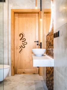 Łazienka z umywalką i drewnianymi drzwiami w obiekcie Przy Szlaku w Zawoi
