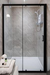 a bathroom with a shower with a glass door at St George's Residence in Glasgow