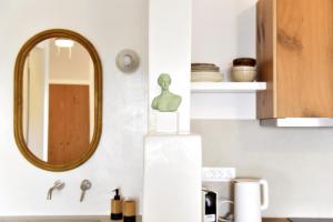 Giourgas Studios & Apartments في Provatas: مرآة على جدار بجوار مطبخ