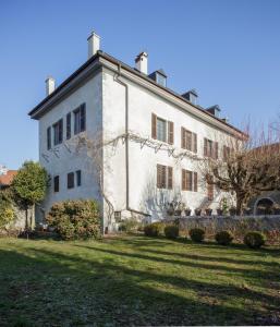 un gran edificio blanco en un campo de césped en Sessius1622, en Cessy