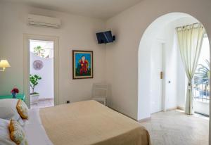 a bedroom with a bed and an arched doorway at Hotel Ossidiana Stromboli Center in Stromboli