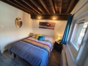 a bedroom with a bed in a room with a window at Appartement cosy dans le centre historique in Châtillon-sur-Chalaronne