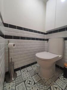a bathroom with a toilet and a tile floor at Appartement cosy dans le centre historique in Châtillon-sur-Chalaronne +3 photos