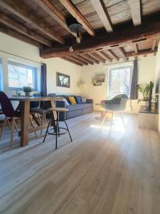 a living room with a couch and a table and chairs at Appartement cosy dans le centre historique in Châtillon-sur-Chalaronne