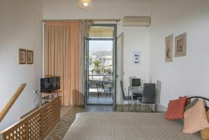 1 dormitorio con 1 cama y balcón con mesa en Annas Sea & City, en Palaiochóra