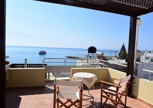 balcón con mesa, sillas y vistas al océano en Annas Sea & City, en Palaiochóra