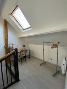 een lege kamer met een tafel en een dakraam bij Aux portes de Beauval in Contres