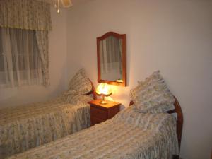 1 dormitorio con 2 camas, espejo y lámpara en Casa Yvonne, en Rojales