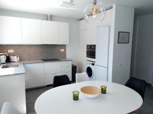 a white kitchen with a white table and chairs at Villa Playa Tauro - Luxury bungalow with pool in Mogán