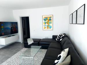 a living room with a black couch and a glass table at Villa Playa Tauro - Luxury bungalow with pool in Mogán