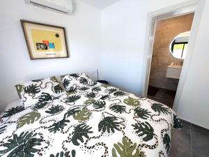 a bedroom with a bed with a green and white comforter at Villa Playa Tauro - Luxury bungalow with pool in Mogán