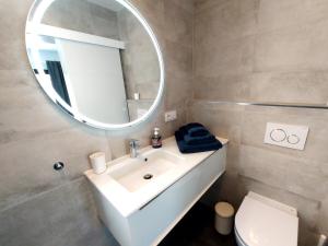 W łazience znajduje się biała umywalka i lustro. w obiekcie Villa Playa Tauro - Luxury bungalow with pool w mieście Mogán