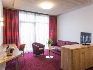 a hotel room with a couch and a table and a tv at Hotel und Gästehaus Kreuz in Gammertingen