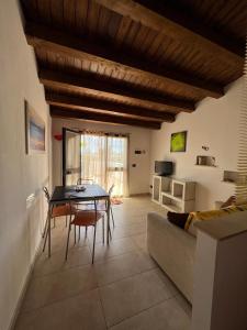 una sala de estar con una mesa y un sofá en Appartamento Geco Rosso, en Marina di Noto