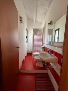 a bathroom with two sinks and a red tile floor at Appartamento Geco Rosso in Noto Marina