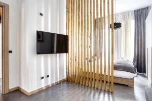 a living room with a tv on a wall at C Studio - Design Bilo Suite -M3- 8 min dal Duomo in Milan
