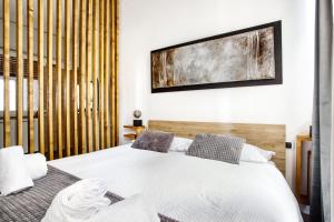 ein Schlafzimmer mit einem weißen Bett und einem TV an der Wand in der Unterkunft C Studio - Design Bilo Suite -M3- 8 min dal Duomo in Mailand