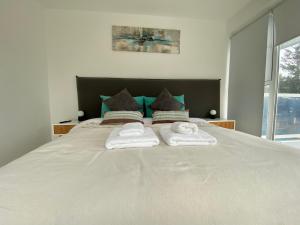 1 dormitorio con 1 cama grande y toallas. en De LOS TEMPANOS en Ushuaia