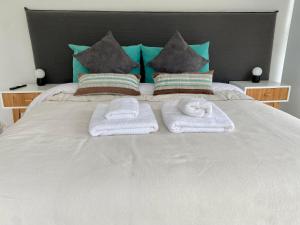1 cama con 2 toallas y almohadas en De LOS TEMPANOS en Ushuaia