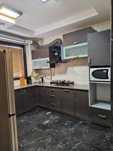 eine Küche mit braunen Schränken und einem Herd mit Backofen in der Unterkunft Palatial 3bhk apartment!Greater kailash 1 in Neu-Delhi