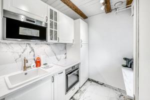 a white kitchen with a sink and a microwave at Château du Châtelard | 2 persons in Montreux