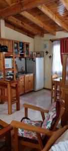 cocina con nevera, mesa y sillas en Lejana Patagonia en Esquel