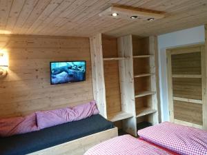 a small room with a bed and a tv on a wall at Beautiful holiday home in a stunning location with sauna in Fügen