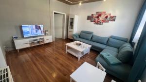 ein Wohnzimmer mit einem blauen Sofa und einem TV in der Unterkunft Ferienwohnung Wetzig W2 - Breite Straße 104 Wernigerode in Wernigerode