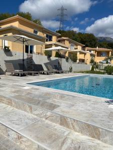 a swimming pool in front of a house at Résidence Pasturella in Bastia