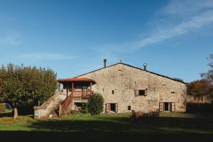 un antiguo edificio de piedra con un balcón en la parte superior. en Casa Do Romualdo, en Vilela