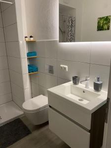 bagno bianco con lavandino e servizi igienici di Einliegerwohnung, Waigolshausen a Waigolshausen