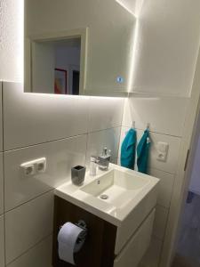 a white bathroom with a sink and a mirror at Einliegerwohnung, Waigolshausen in Waigolshausen