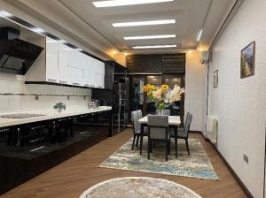 a kitchen with a table with chairs and a vase of flowers at Grand Sea View Megafun in Baku