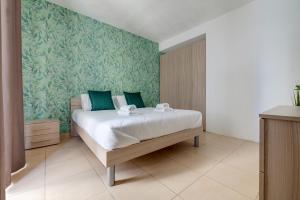 a bedroom with a large bed with green wallpaper at Sliema Tigne Suites in Sliema