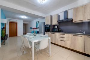 a kitchen with a white table and white chairs at Sliema Tigne Suites in Sliema