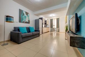 a living room with a couch and a tv at Sliema Tigne Suites in Sliema