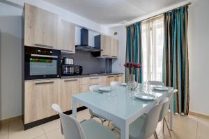 a kitchen with a table and chairs in a kitchen at Sliema Tigne Suites in Sliema