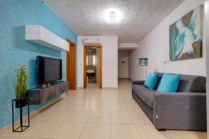 a living room with a couch and a tv at Sliema Tigne Suites in Sliema