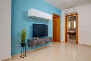 a living room with a tv on a blue wall at Sliema Tigne Suites in Sliema