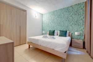 a bedroom with a bed with a green wall at Sliema Tigne Suites in Sliema